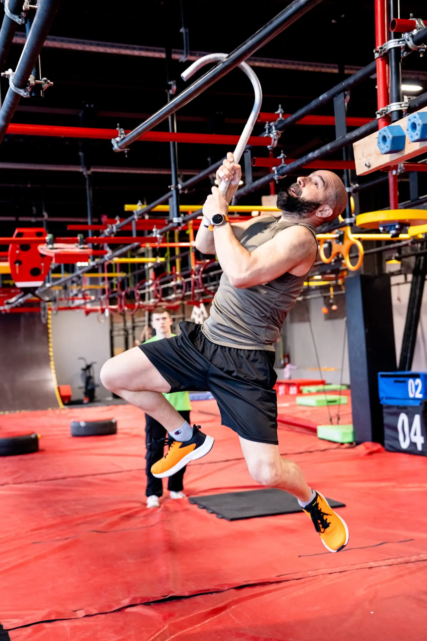 Взрослый спортсмен проходит ниндзя-препятствие в EL-FIT